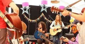 Picture of me teaching guitar to children at a festival